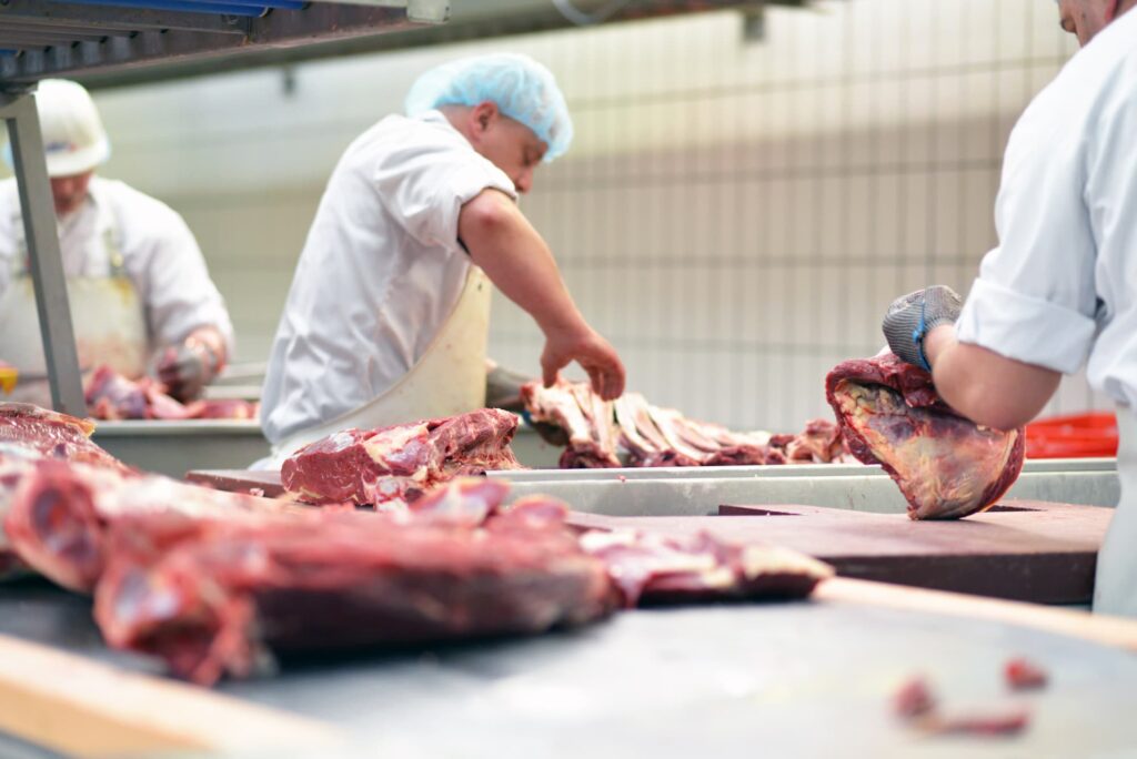 boucherie : équipe de bouchers artisans travaillant la viande crue pour les commandes des clients depuis la boucherie en ligne