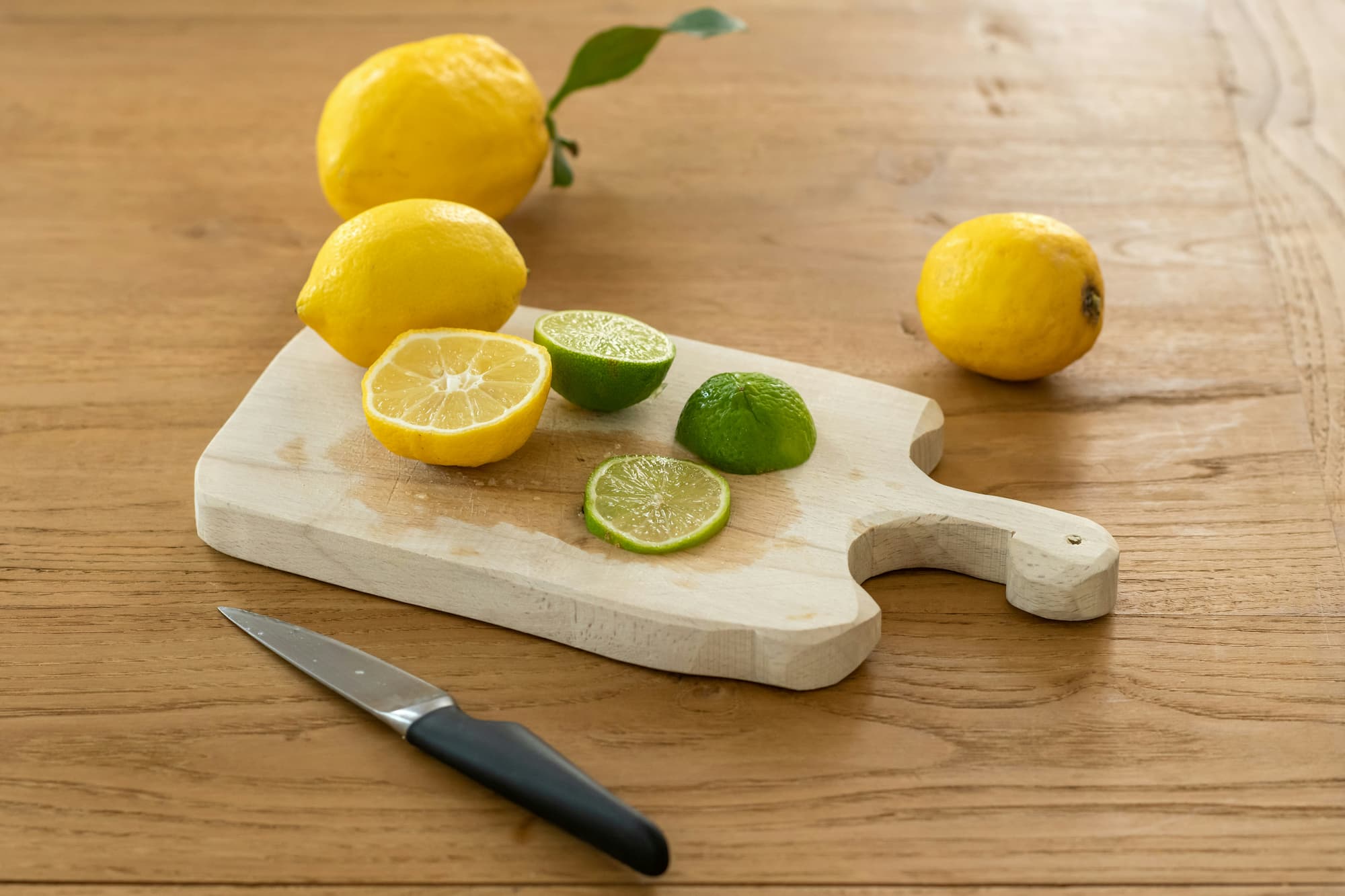 citron jaune et citron vert sur une planche à découper